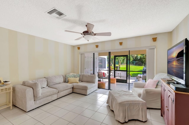 living room featuring ceiling fan, a textured ceiling, light tile patterned flooring, and visible vents