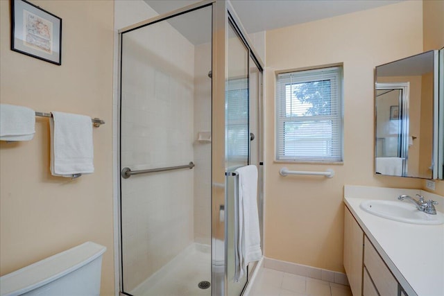 bathroom featuring baseboards, a shower stall, toilet, and vanity