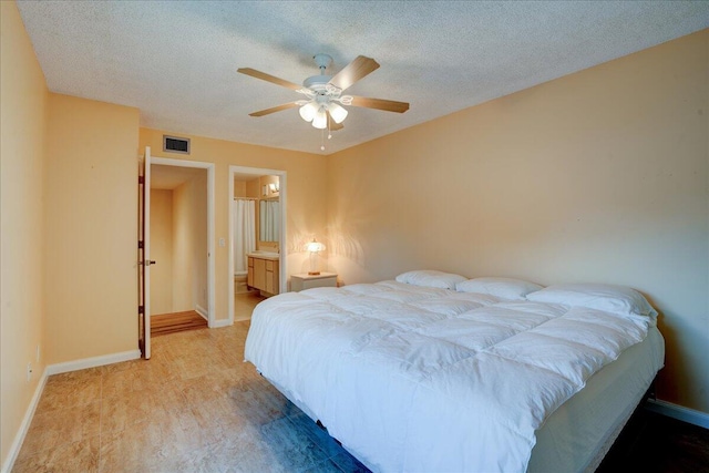 bedroom featuring visible vents, light wood-style flooring, ceiling fan, a textured ceiling, and baseboards