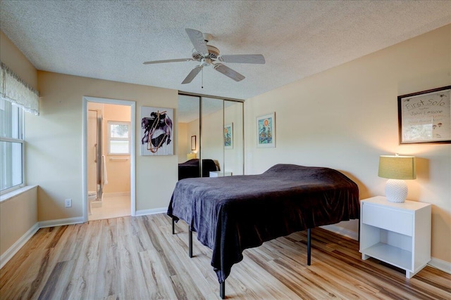 bedroom featuring a closet, a textured ceiling, baseboards, and wood finished floors