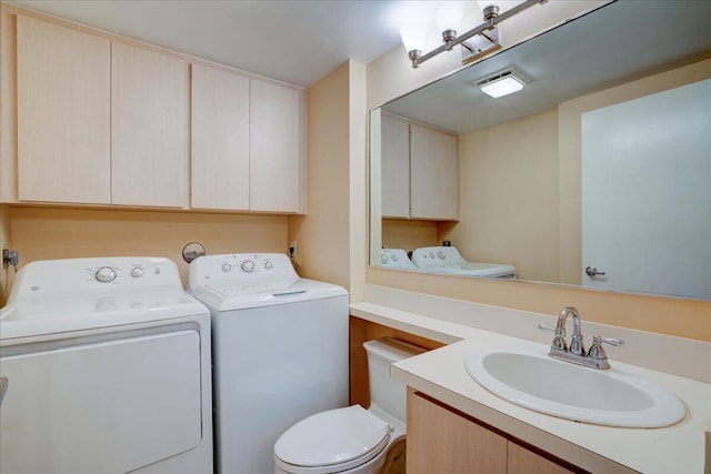 bathroom featuring toilet, washer and clothes dryer, and vanity