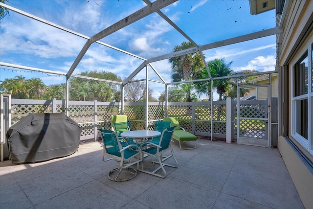 view of patio with glass enclosure and area for grilling