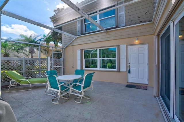 view of patio / terrace featuring outdoor dining space and a lanai