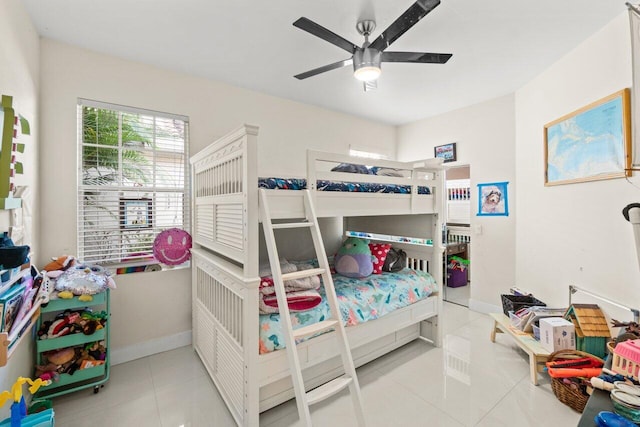 tiled bedroom with ceiling fan and baseboards