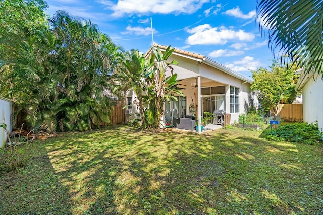 view of yard with a sunroom, a fenced backyard, and a patio area