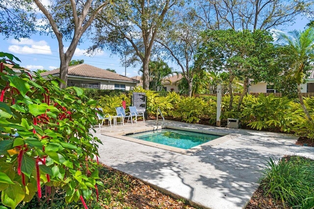 view of pool with a patio and a hot tub