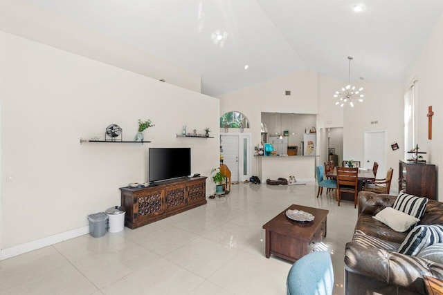 living room with an inviting chandelier, baseboards, light tile patterned floors, and high vaulted ceiling