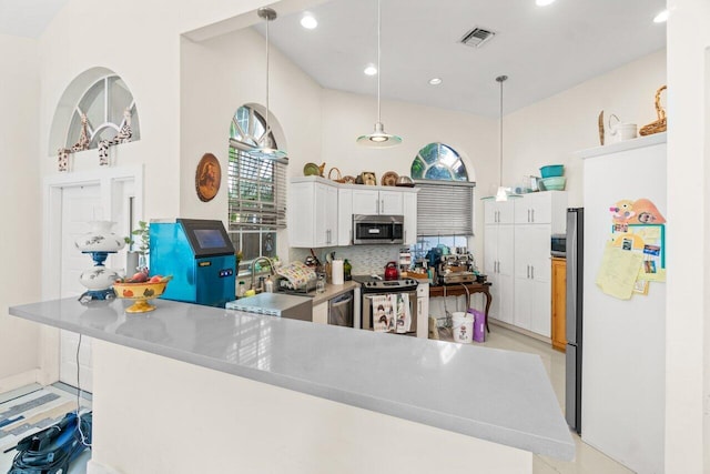 kitchen with a sink, visible vents, white cabinetry, appliances with stainless steel finishes, and decorative backsplash