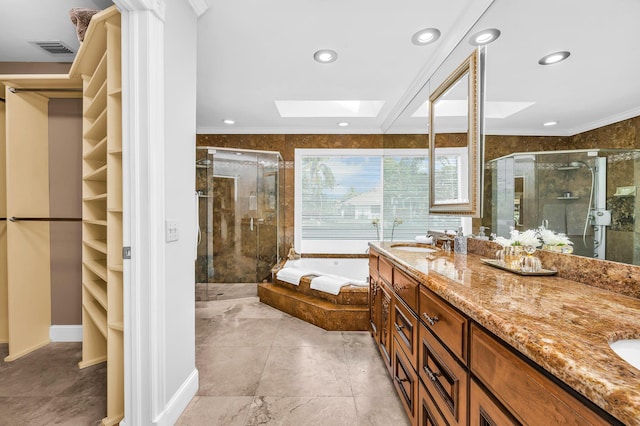 bathroom with a skylight, a sink, a shower stall, and a bath