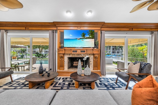 living room with a sunroom, ceiling fan, and a fireplace