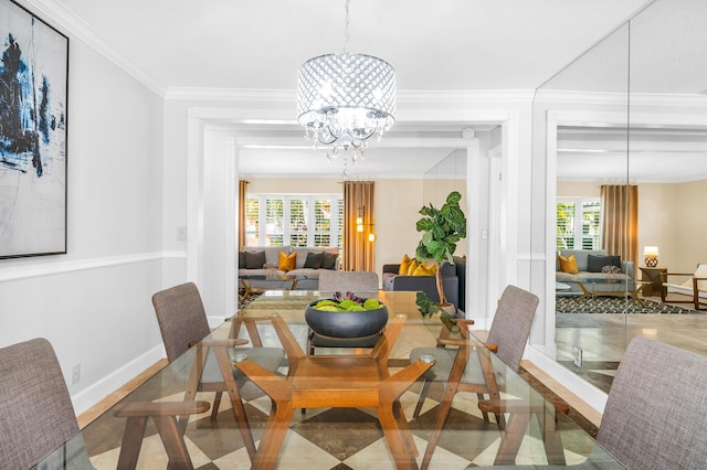 dining area with a healthy amount of sunlight, a notable chandelier, baseboards, and crown molding