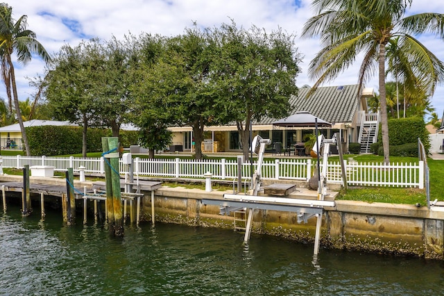 view of dock featuring a water view, boat lift, fence, and a gazebo