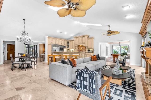 living area featuring lofted ceiling with skylight, baseboards, and ceiling fan with notable chandelier