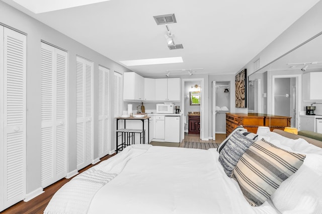 bedroom featuring track lighting, visible vents, and dark wood-type flooring