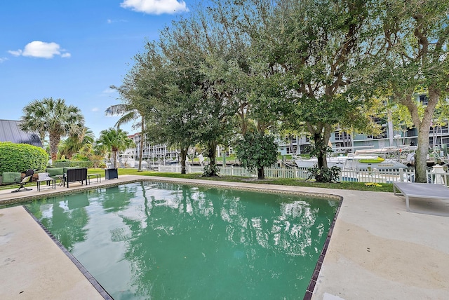 outdoor pool featuring a patio area and fence