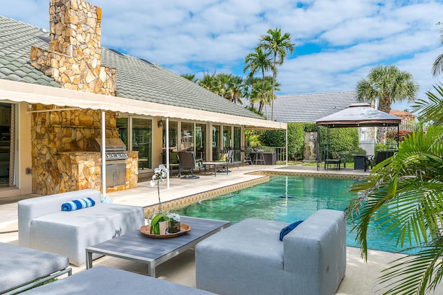 pool with a patio area, an outdoor kitchen, area for grilling, and a gazebo