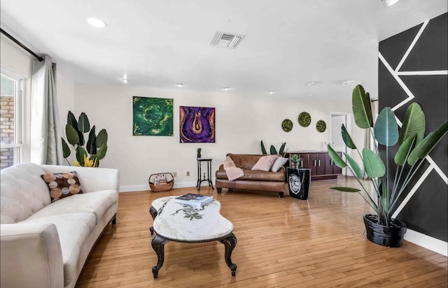 living area with light wood finished floors, baseboards, and visible vents