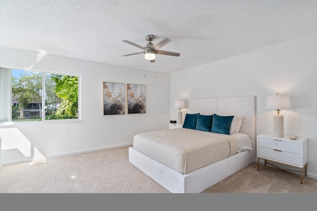 bedroom with carpet floors, a ceiling fan, baseboards, and a textured ceiling