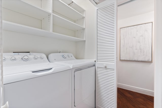 laundry area featuring washer and dryer, baseboards, and wood finished floors