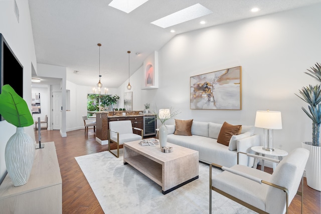 living room featuring beverage cooler, baseboards, wood finished floors, a chandelier, and recessed lighting