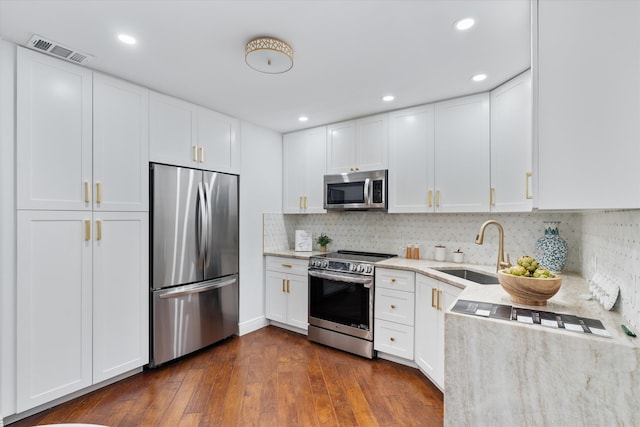 kitchen with a sink, visible vents, white cabinetry, appliances with stainless steel finishes, and dark wood-style floors