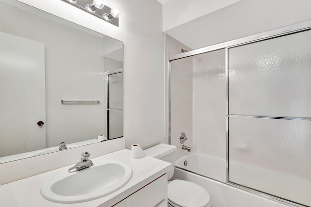 full bathroom featuring toilet, shower / bath combination with glass door, and vanity