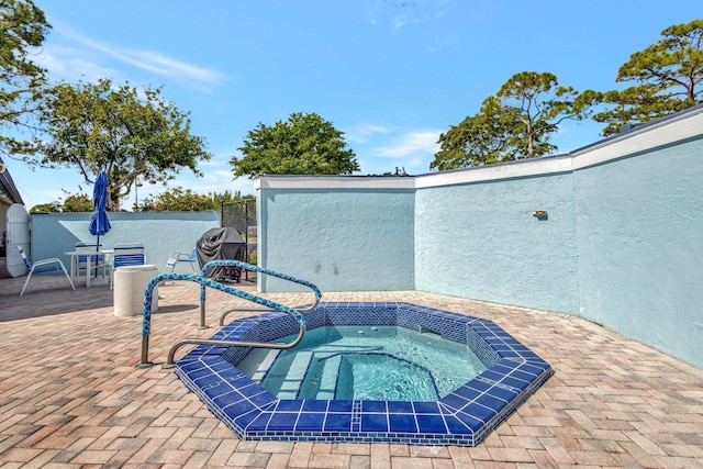 view of swimming pool featuring a patio area and a hot tub