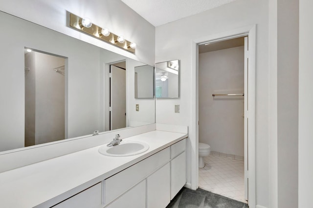 full bath with baseboards, a spacious closet, toilet, and vanity