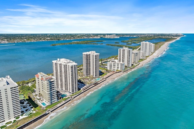 drone / aerial view with a city view, a view of the beach, and a water view