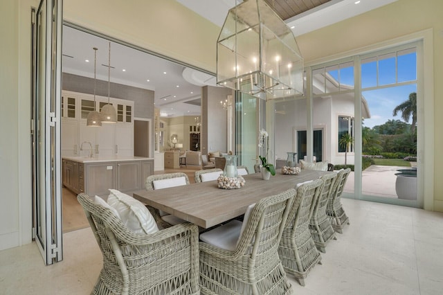 dining area featuring recessed lighting, light tile patterned flooring, a notable chandelier, and a high ceiling