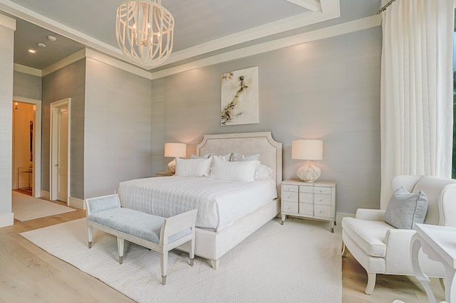 bedroom featuring a tray ceiling, baseboards, light wood finished floors, and an inviting chandelier