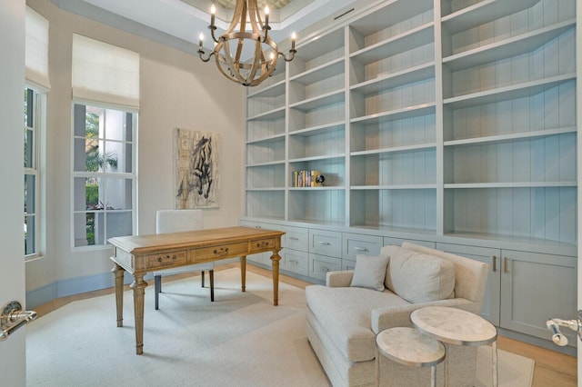 home office featuring a notable chandelier, baseboards, light wood-style flooring, and built in features