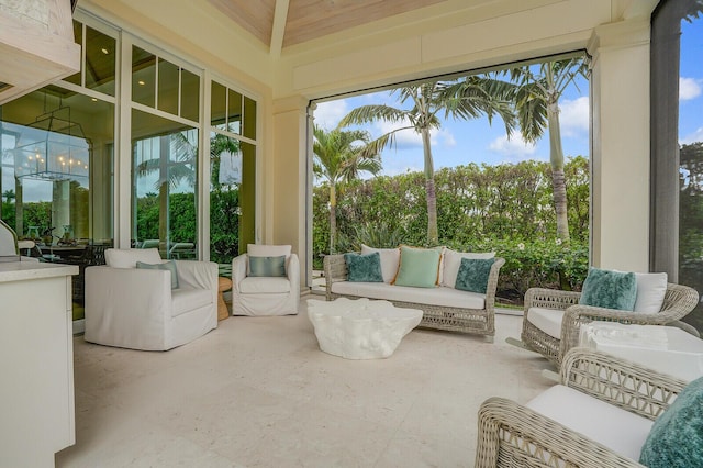 sunroom / solarium with a healthy amount of sunlight and an inviting chandelier