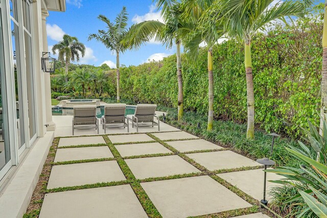 view of patio / terrace with an in ground hot tub