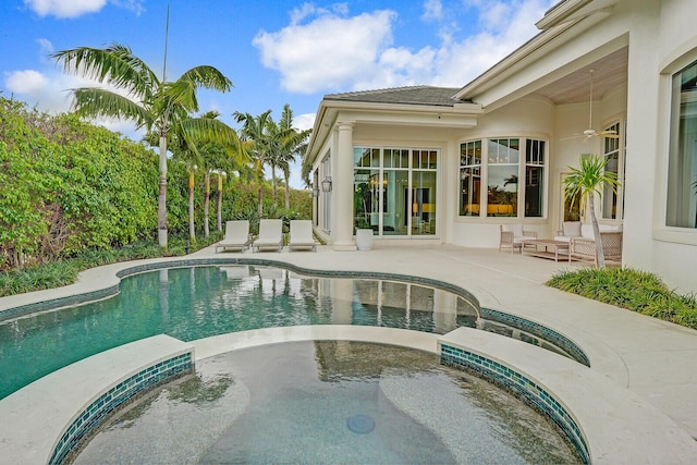 pool with a patio and an in ground hot tub