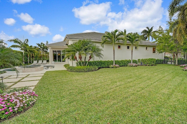 back of property with stucco siding, a yard, a patio, and fence