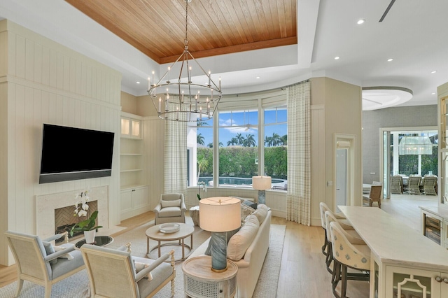 living room featuring built in shelves, a tray ceiling, a premium fireplace, wood ceiling, and a healthy amount of sunlight