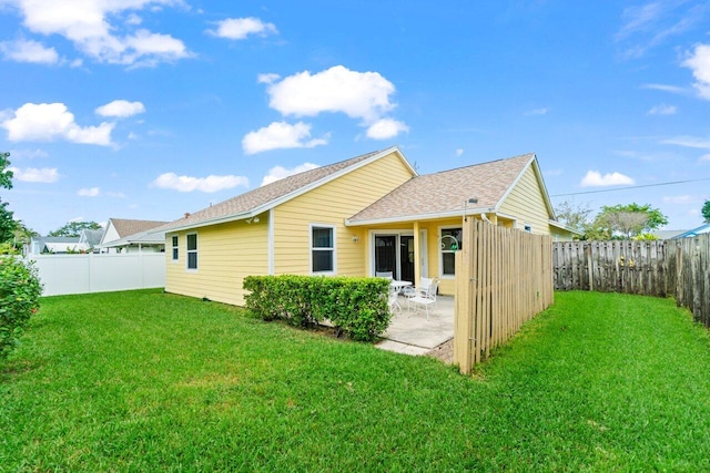 rear view of property featuring a patio area, a fenced backyard, and a lawn