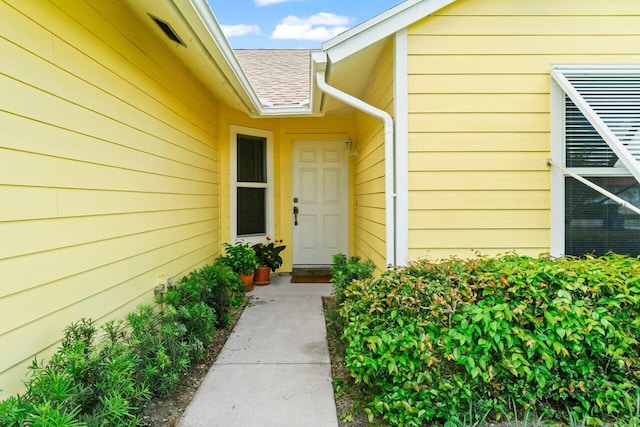 property entrance featuring roof with shingles