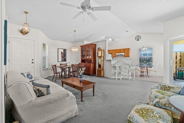 living room with light carpet, vaulted ceiling, a textured ceiling, and ceiling fan