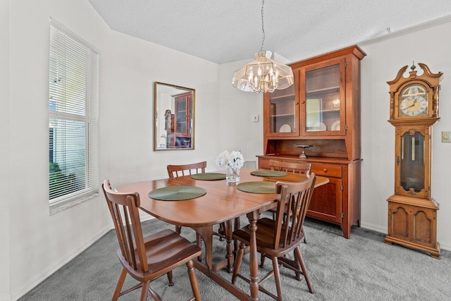 dining space with baseboards, a chandelier, a textured ceiling, and light colored carpet