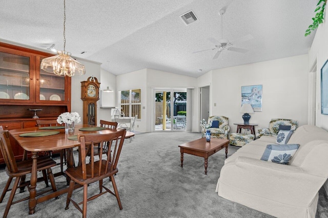 carpeted dining space with lofted ceiling, a textured ceiling, ceiling fan with notable chandelier, and visible vents