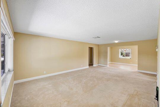 spare room with baseboards and a textured ceiling