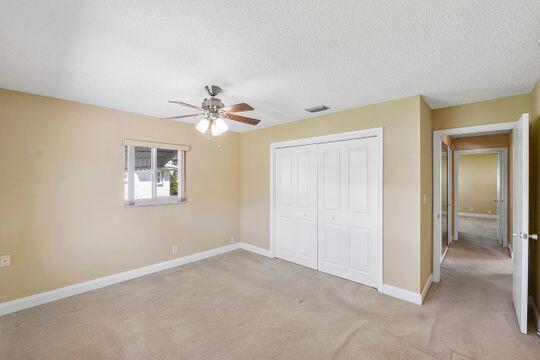 unfurnished bedroom featuring baseboards, visible vents, a closet, and a textured ceiling