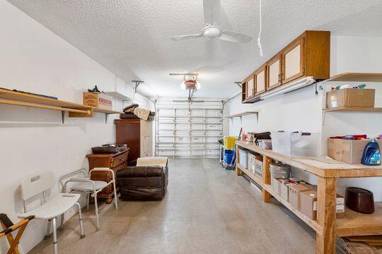 garage with a garage door opener and ceiling fan