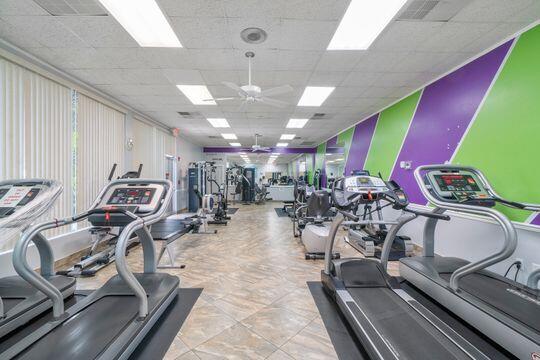 exercise room with visible vents, ceiling fan, and a drop ceiling