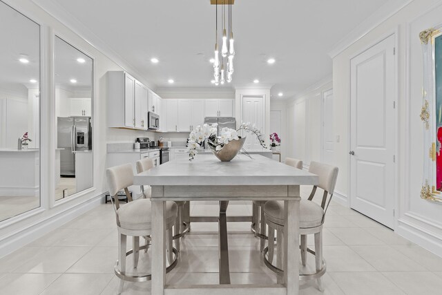 dining room with light tile patterned floors, ornamental molding, and a decorative wall