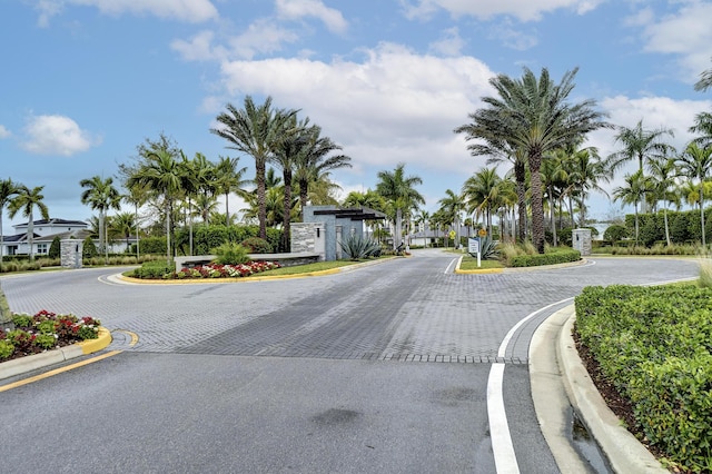 view of street featuring traffic signs, curbs, and a gated entry