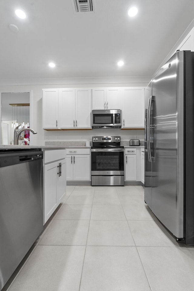 kitchen with light tile patterned floors, stainless steel appliances, visible vents, and white cabinets