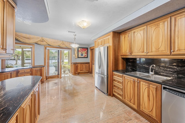 kitchen with brown cabinets, stainless steel appliances, visible vents, wainscoting, and a sink